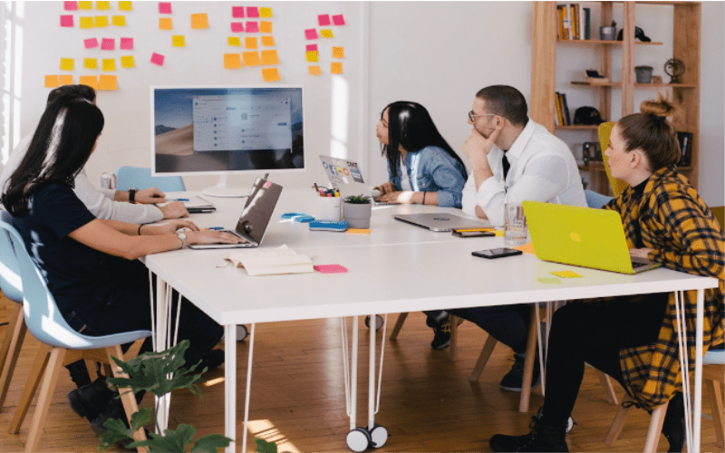 A team in an office discussing leadership in sales during a meeting